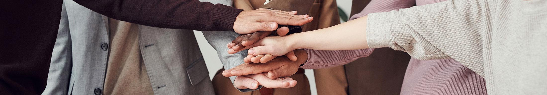 people hands stacked representing teamwork